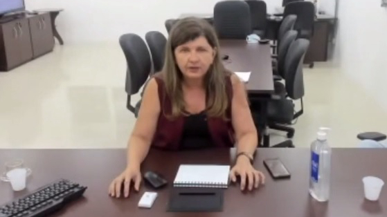 secretária falando sentada à mesa